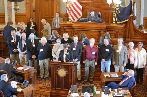 Etzanoa Conservancy personnel stand in the Kansas House of Representatives.